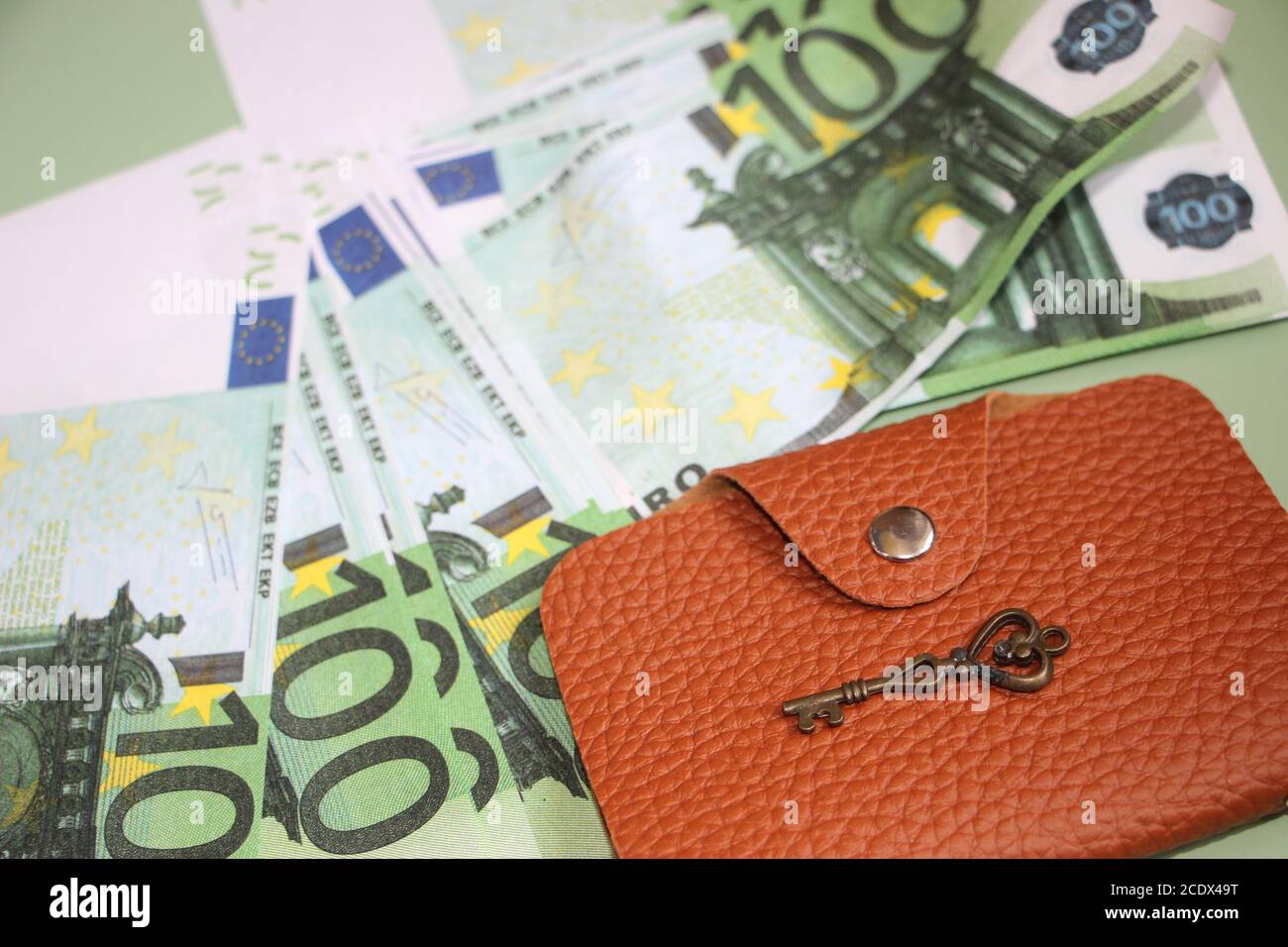 Molte banconote da 100 euro, portafoglio in pelle marrone e chiave vintage.  Concetto aziendale Foto stock - Alamy