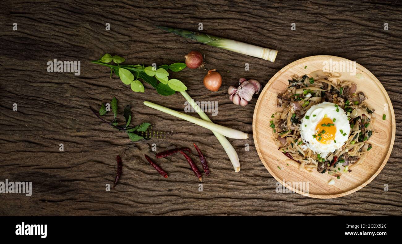 Carne fritta con germoglio di bambù e basilico santo servito con uova fritte di riso al vapore Foto Stock
