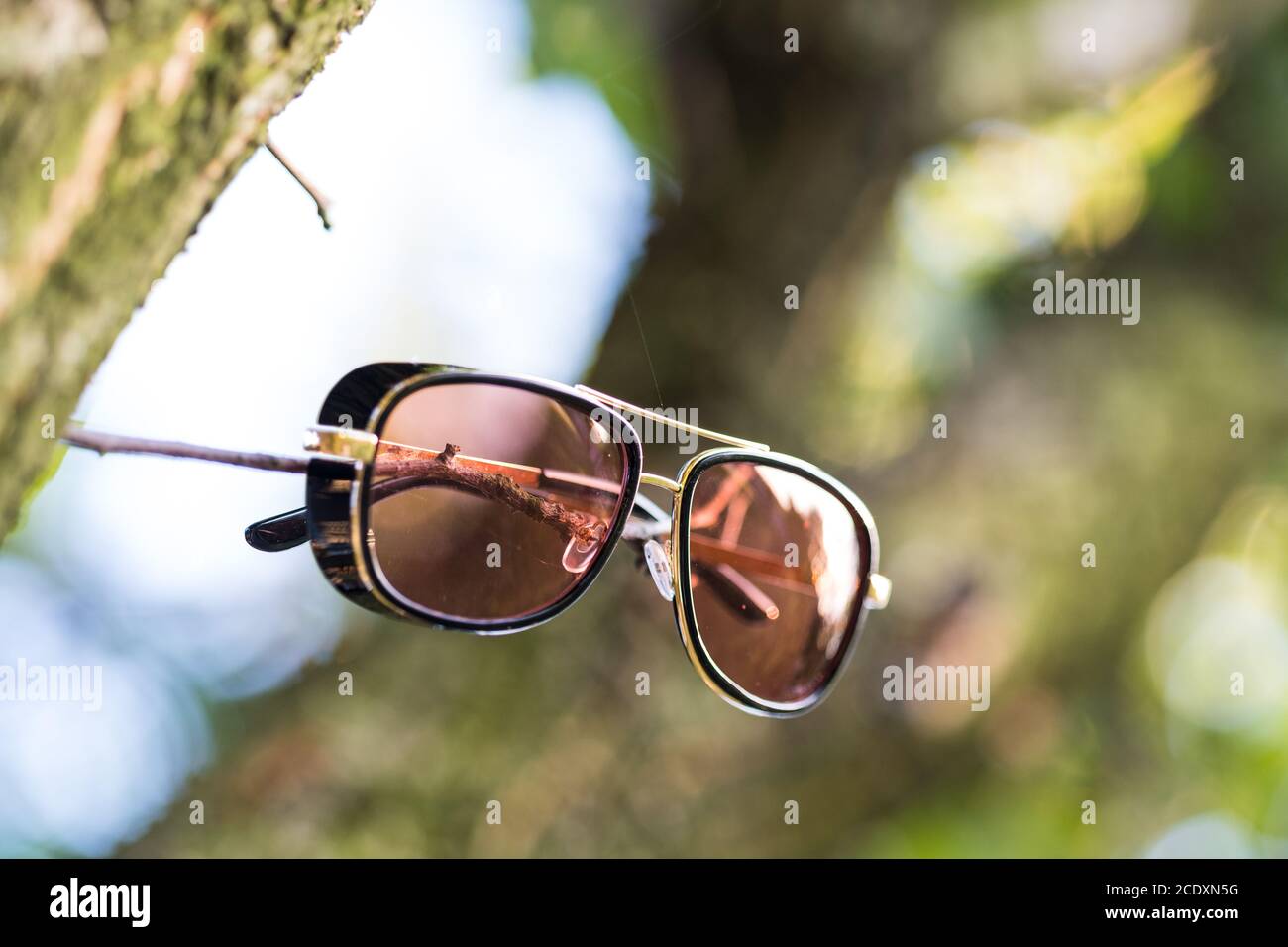 Occhiali da sole retrò modello con lenti rosse sparare in una giornata  estiva in closeup natura. Messa a fuoco selettiva Foto stock - Alamy