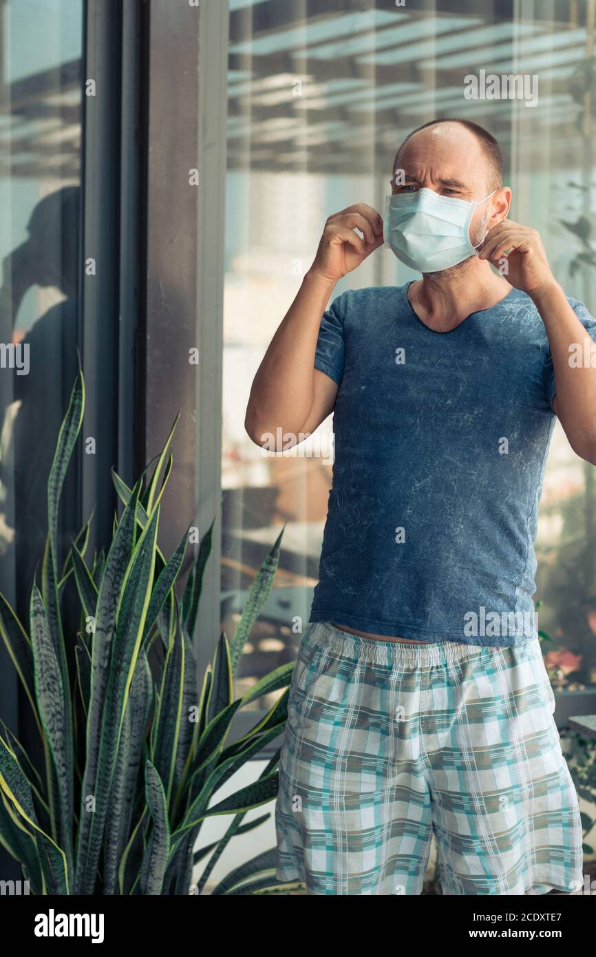 Uomo che indossa una maschera facciale monouso. Protezione da virus Foto Stock