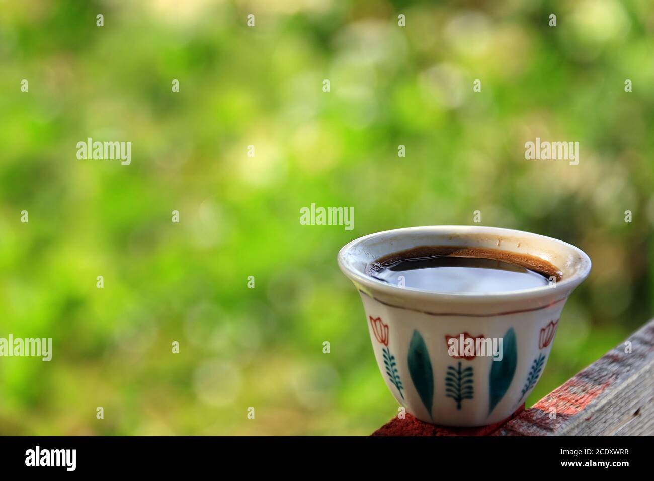 Una tradizionale tazza di caffè libanese su sfondo verde. Foto Stock