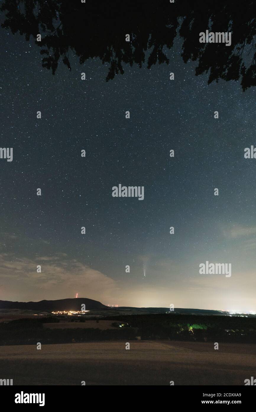 Vista notturna verso la montagna di Donnersberg con cieli stellati, tra cui la cometa Neoswise C/2020 F3, girato vicino a Goellheim, Rhinehesse Germania. Foto Stock
