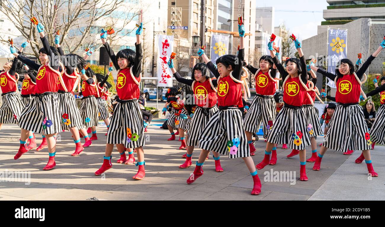 Gruppo di ballerini giapponesi yosakoi che ballano con naruko, clapper in legno, durante il festival di danza Kumamoto Kyusyu Gassai in Giappone. Foto Stock