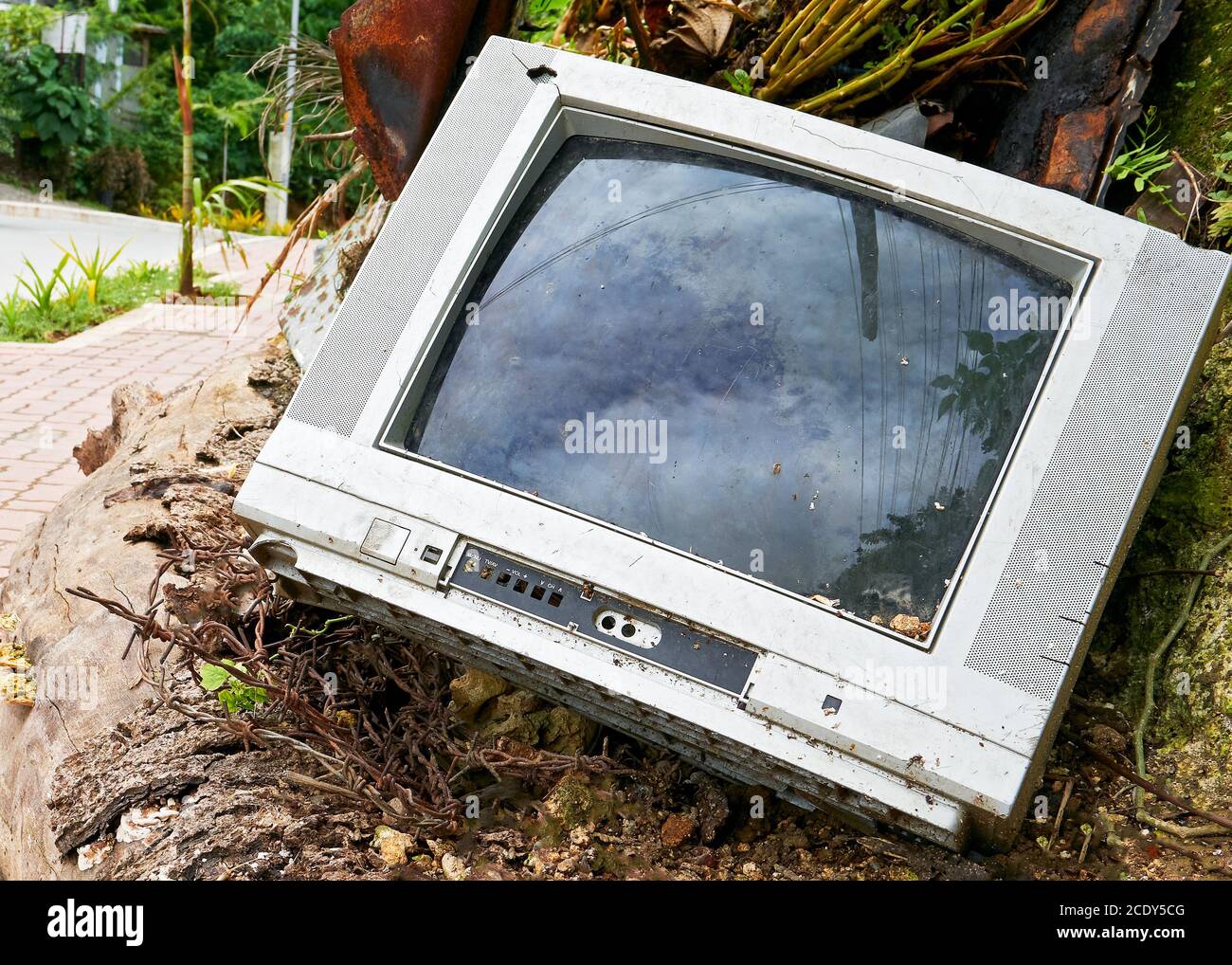 Un vecchio televisore analogico rotto è stato scaricato lungo la strada da un consumatore irresponsabile in Asia Foto Stock