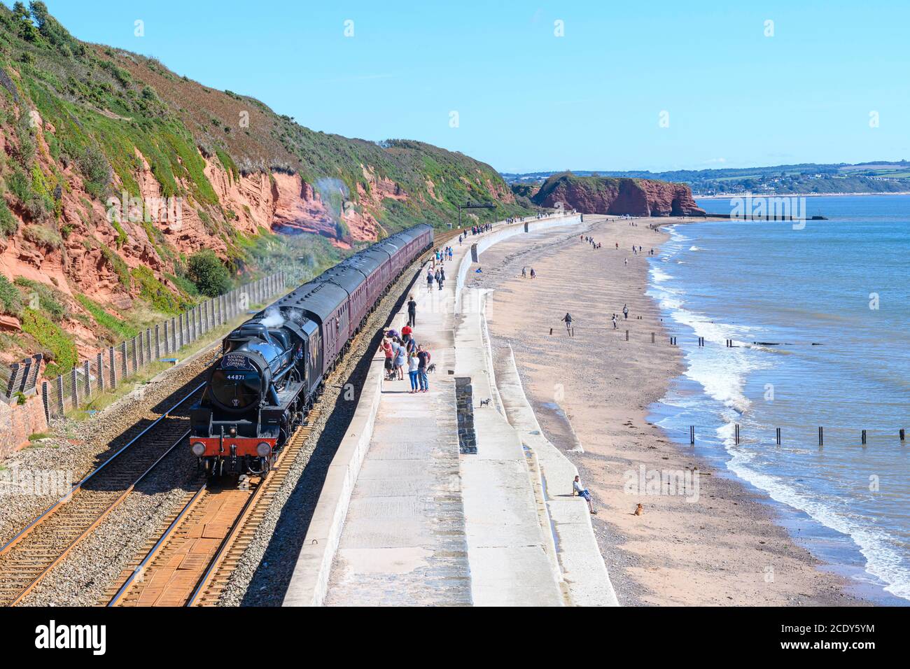 Locomotiva a vapore 44871 'Black Five' che trasporta il treno del Ducato reale passando il muro di mare Dawlish sud Devon UK. Foto Stock