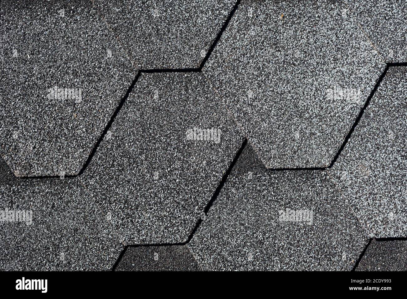 Closeup di struttura di tegole di asfalto grigio. Tetto coperto da tegole o tegole morbide esagonali. Sfondo geometrico astratto Foto Stock