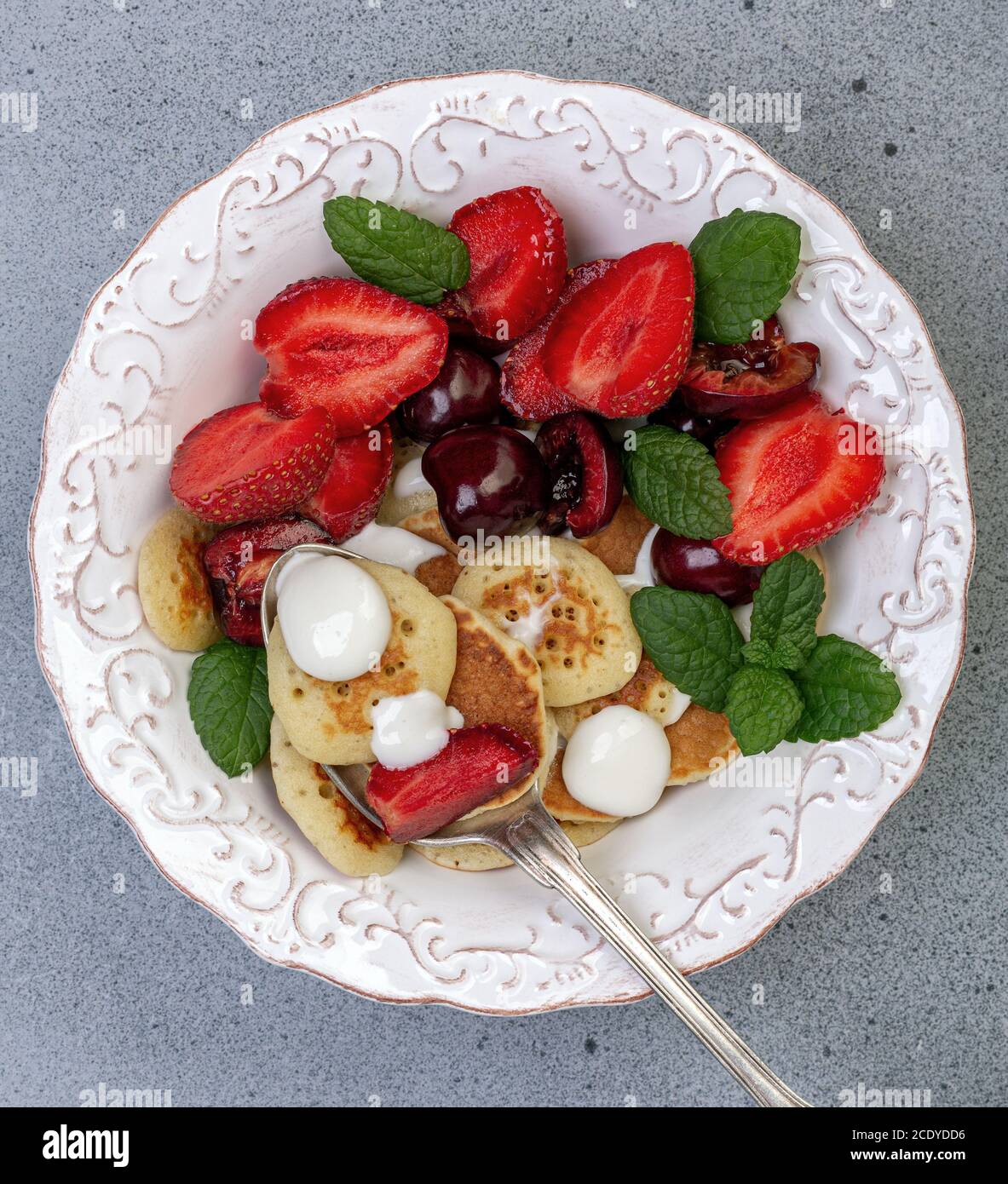 Minuscoli pancake con frutti di bosco. Cibo alla moda. Foto Stock