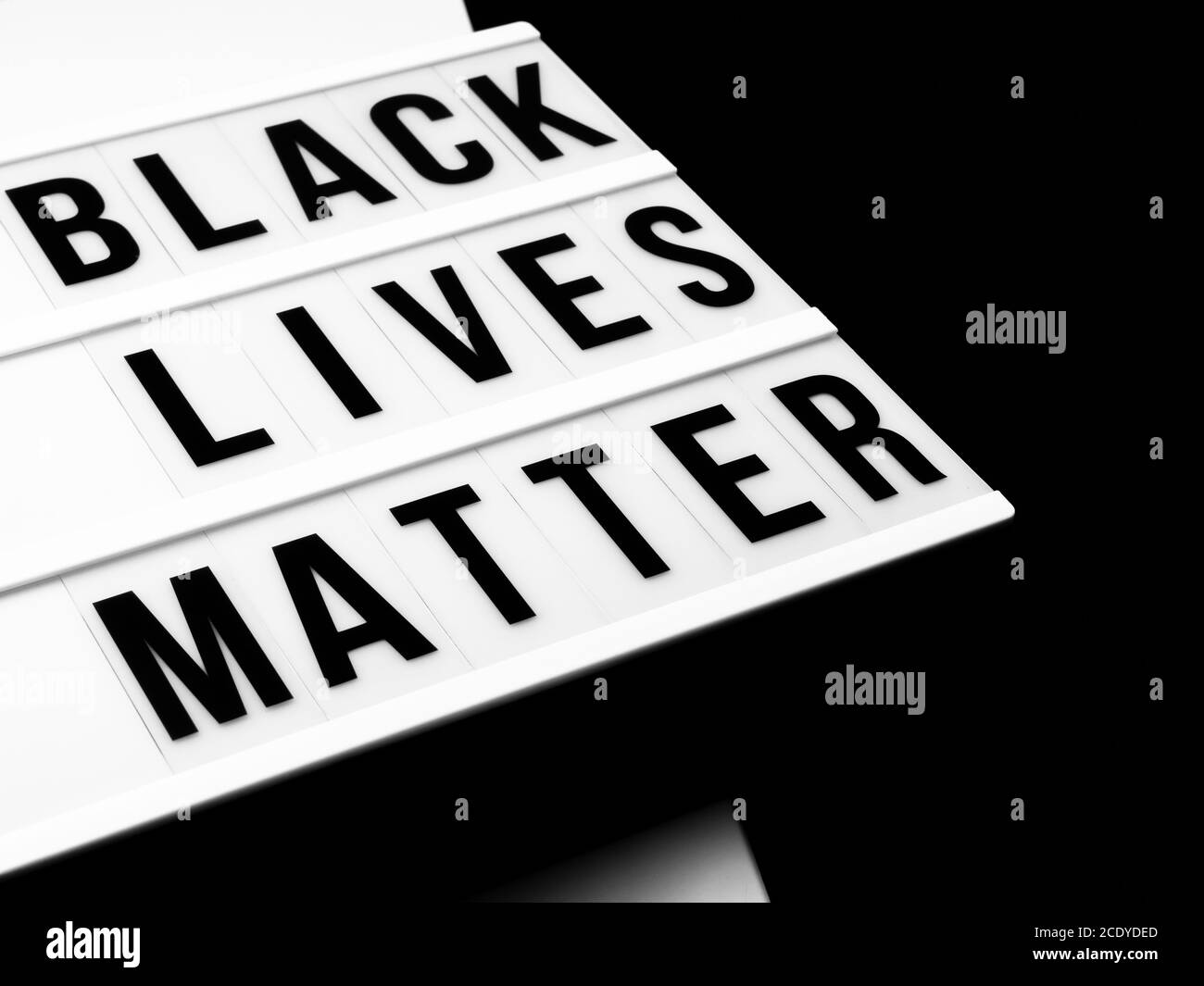 Casella di luce con il testo nero vive materia contro il nero e sfondo bianco Foto Stock