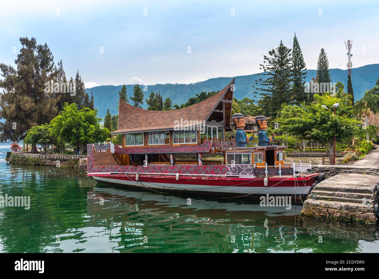 Barca con figure giganti sul lago Toba a Sumatra Foto Stock