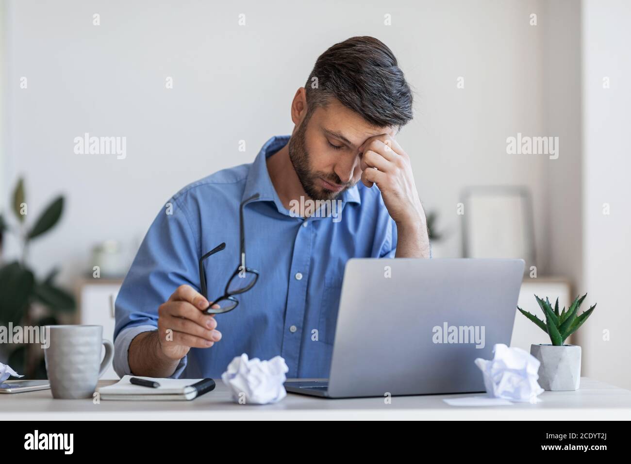 Affaticamento degli occhi. Uomo d'affari overworking stanco dopo una lunga giornata lavorativa in ufficio Foto Stock