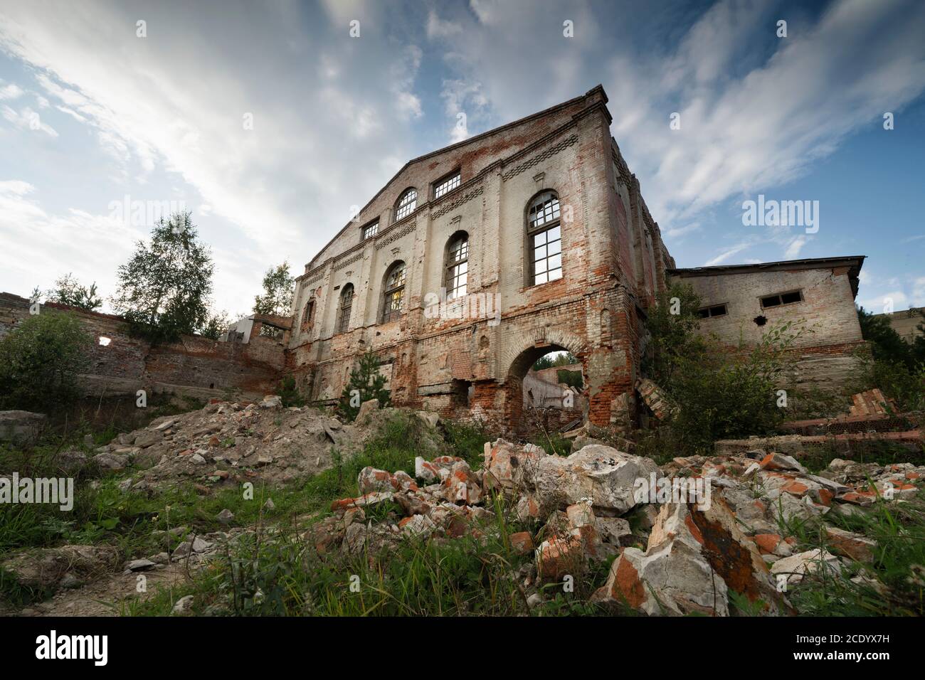 la vecchia facciata in mattoni dell'edificio del 19 ° secolo, distrutto da tutti i venti, sotto il cielo aperto blu. foto atmosferica Foto Stock