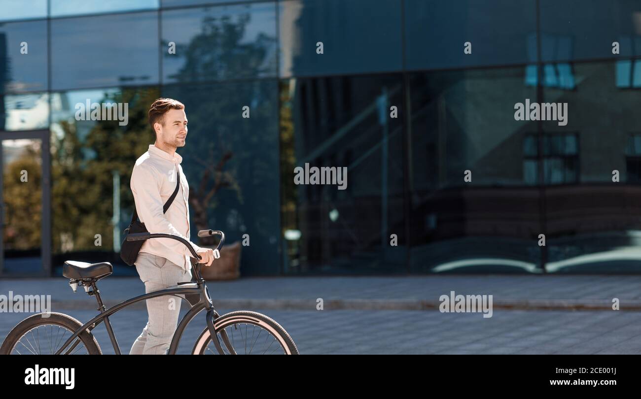 Trasporti, stile di vita e attività. Ragazzo in abiti formali va con la bicicletta Foto Stock