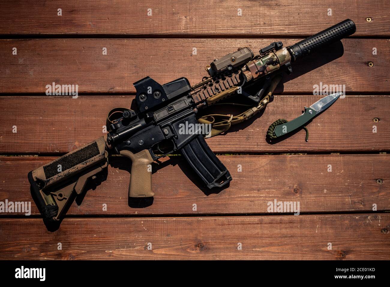 Sopra la vista del fucile moderno e coltello su tavola di legno, concetto di armi da soldati Foto Stock
