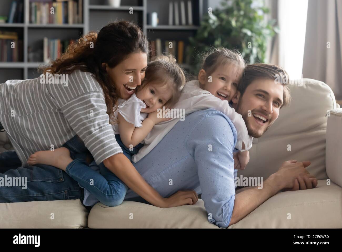 Sorridente bonding famiglia godendo tempo di gioco insieme a casa. Foto Stock