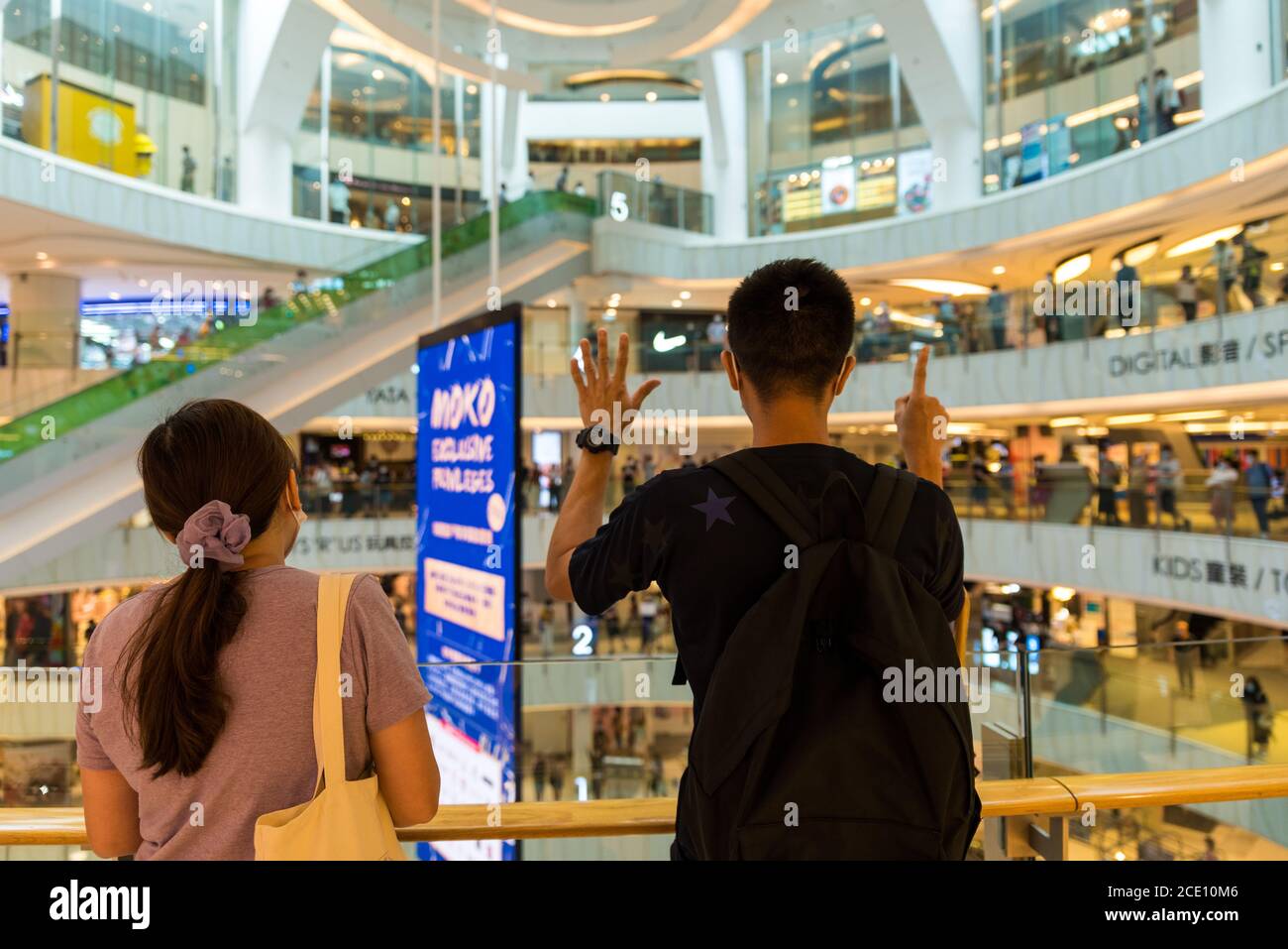 Hong Kong, Cina. 30 agosto 2020. Un protestante fa il segno 'cinque richieste non di meno' mentre l'inno 'Glory to Hong Kong' è cantato nel centro commerciale di Moko. Le chiamate online sono andate in occasione del primo anniversario degli '8.31 attacchi', un violento intervento della polizia nella stazione MTR di Prince Edwards. Circa cinquanta persone si sono riunite al massimo nel centro commerciale, che è stato poi investito dalla polizia sommossa per disperdere i manifestanti. Credit: Marc R Fernandes/Alamy Live News Foto Stock