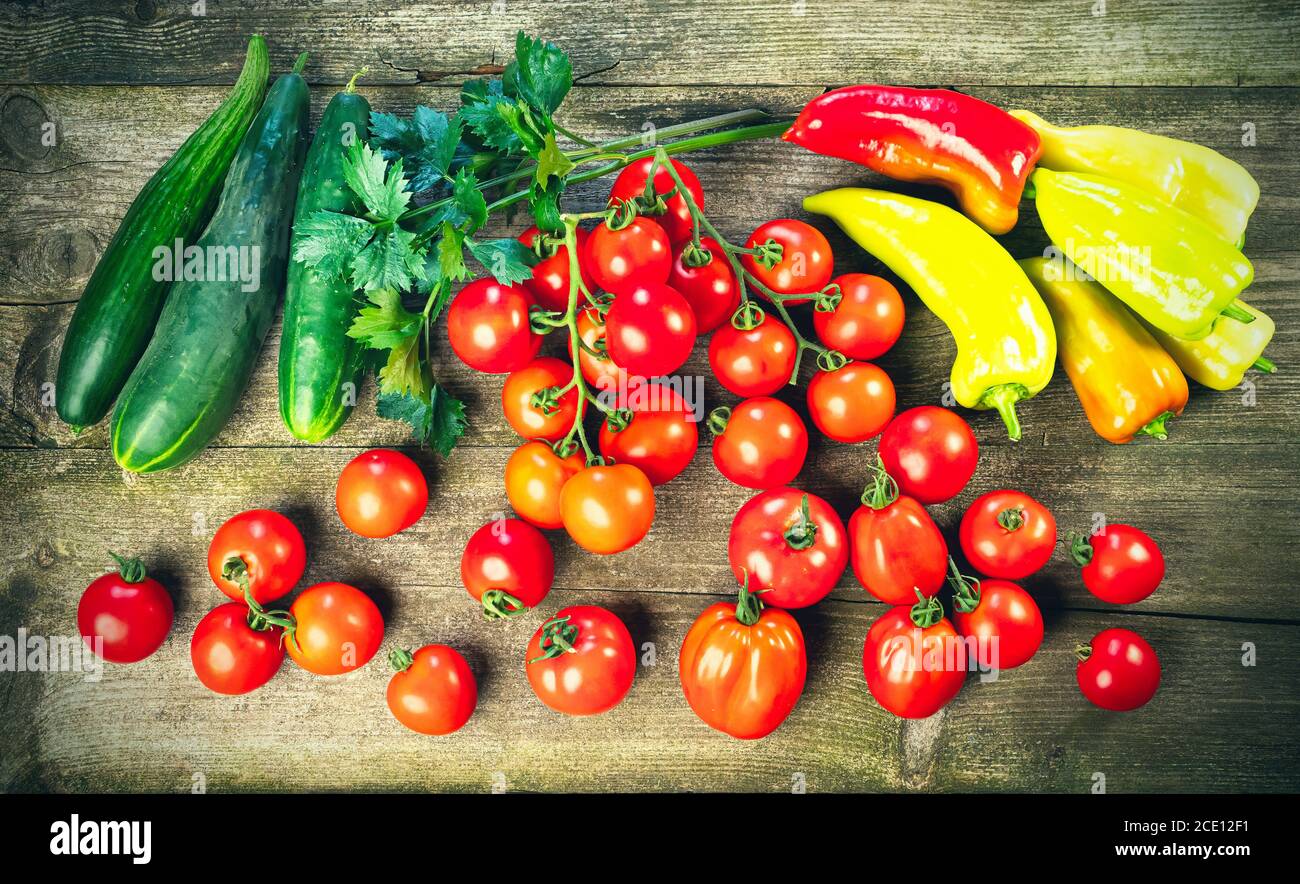 Raccolta di verdure fresche mature su tavola di legno - pepe, pomodoro, cetriolo, foglie di sedano. Cibo biologico sano, vitamine estive, viands BIO, naturale Foto Stock