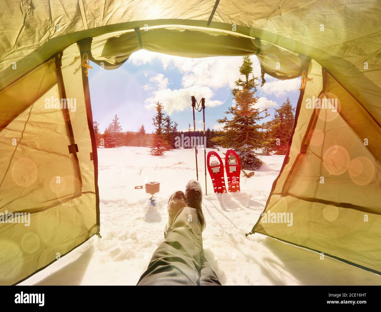 Tenda nel paesaggio invernale. Tenda da trekking, bastoni, racchette da neve rosse sulla neve Foto Stock