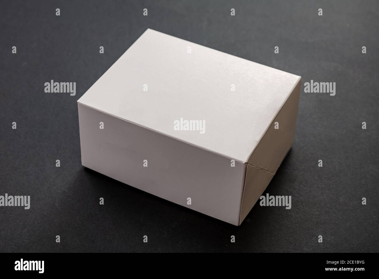 Rettangolo della confezione, modello pubblicitario vuoto per la confezione dei prodotti. Contenitore di cartone chiuso vuoto di colore bianco su sfondo nero Foto Stock