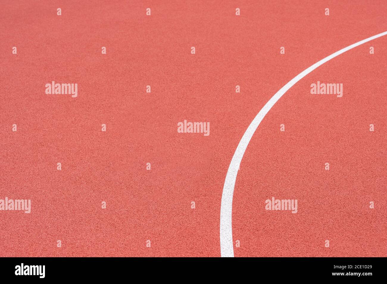 Primo piano su una linea bianca in erba rossa artificiale, su una strada di pallacanestro, pallamano, pallavolo, futsal, rugby, hockey e campo di calcio, in uno sport b Foto Stock