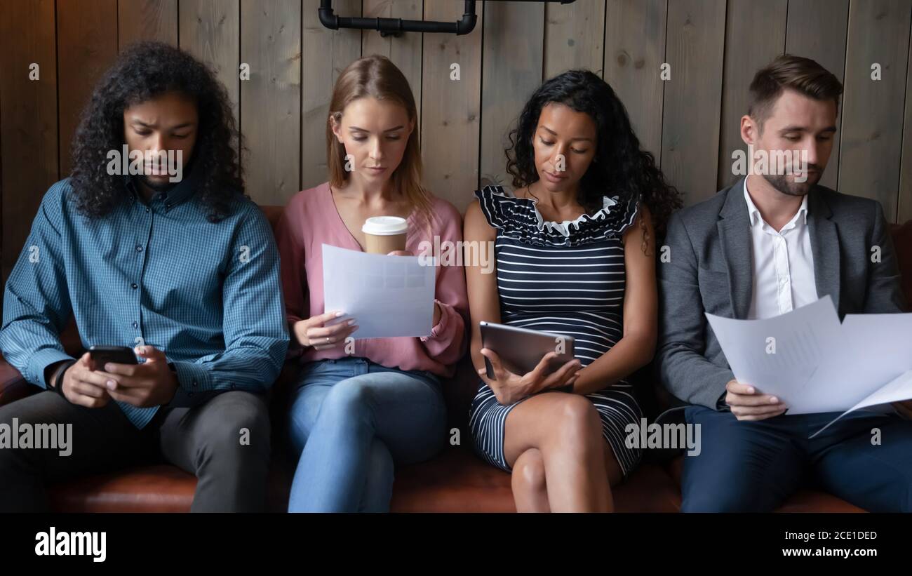 Persone diverse candidati in attesa di intervista, seduta di fila Foto Stock