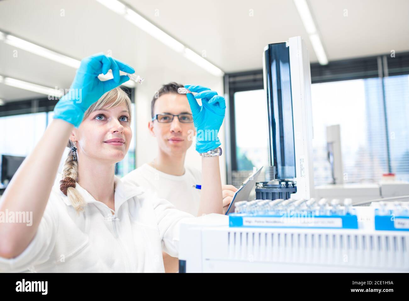 Due giovani ricercatori che svolgono ricerche scientifiche in un laboratorio utilizzando un gascromatografo (DOF poco profondo; immagine a colori) Foto Stock