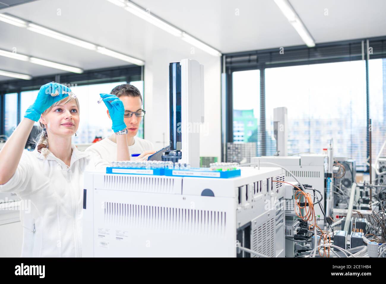 Due giovani ricercatori che svolgono ricerche scientifiche in un laboratorio utilizzando un gascromatografo (DOF poco profondo; immagine a colori) Foto Stock