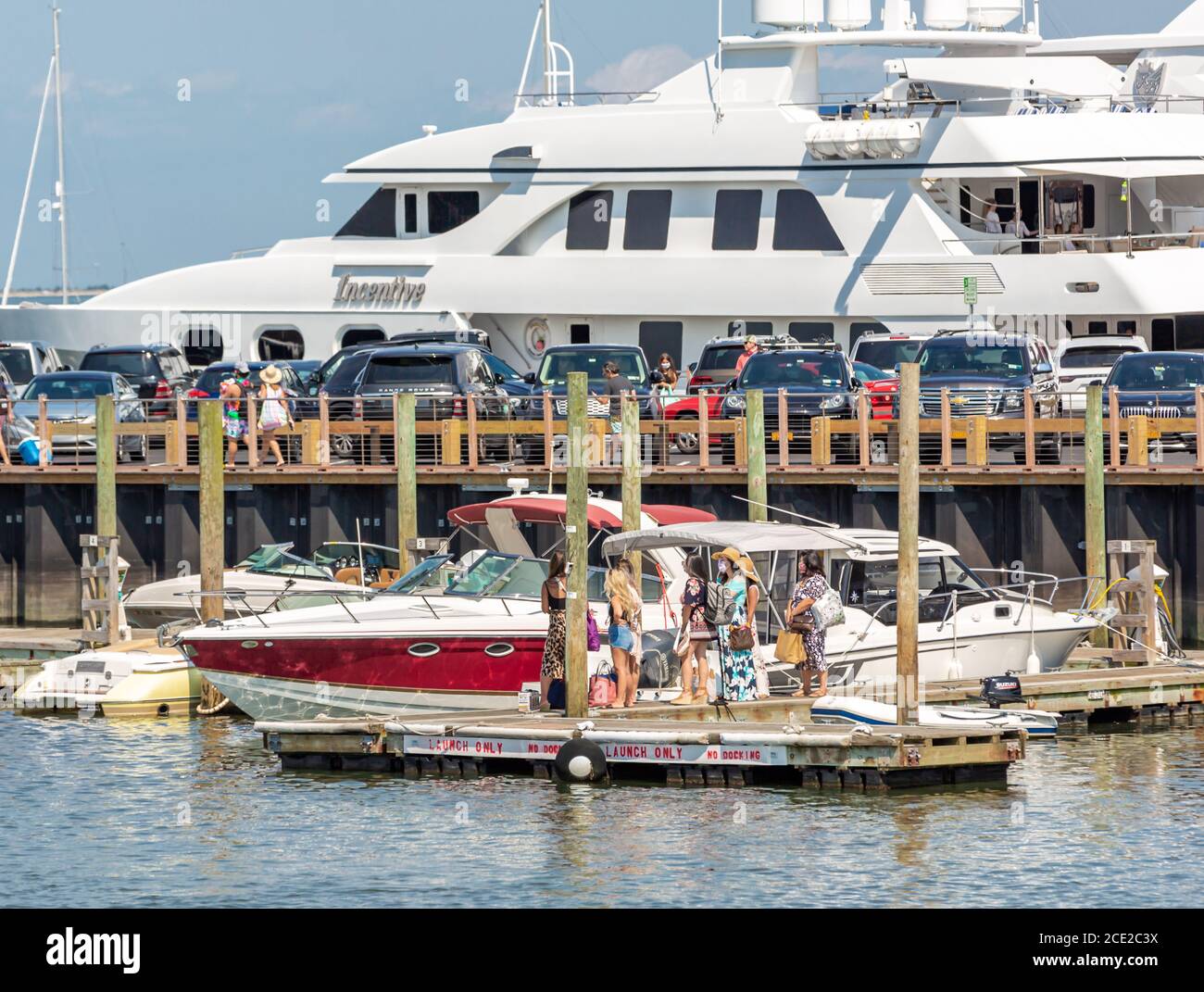 Gruppo di donne che indossano maschere in attesa di una barca a Long Wharf, Sag Harbour, NY Foto Stock