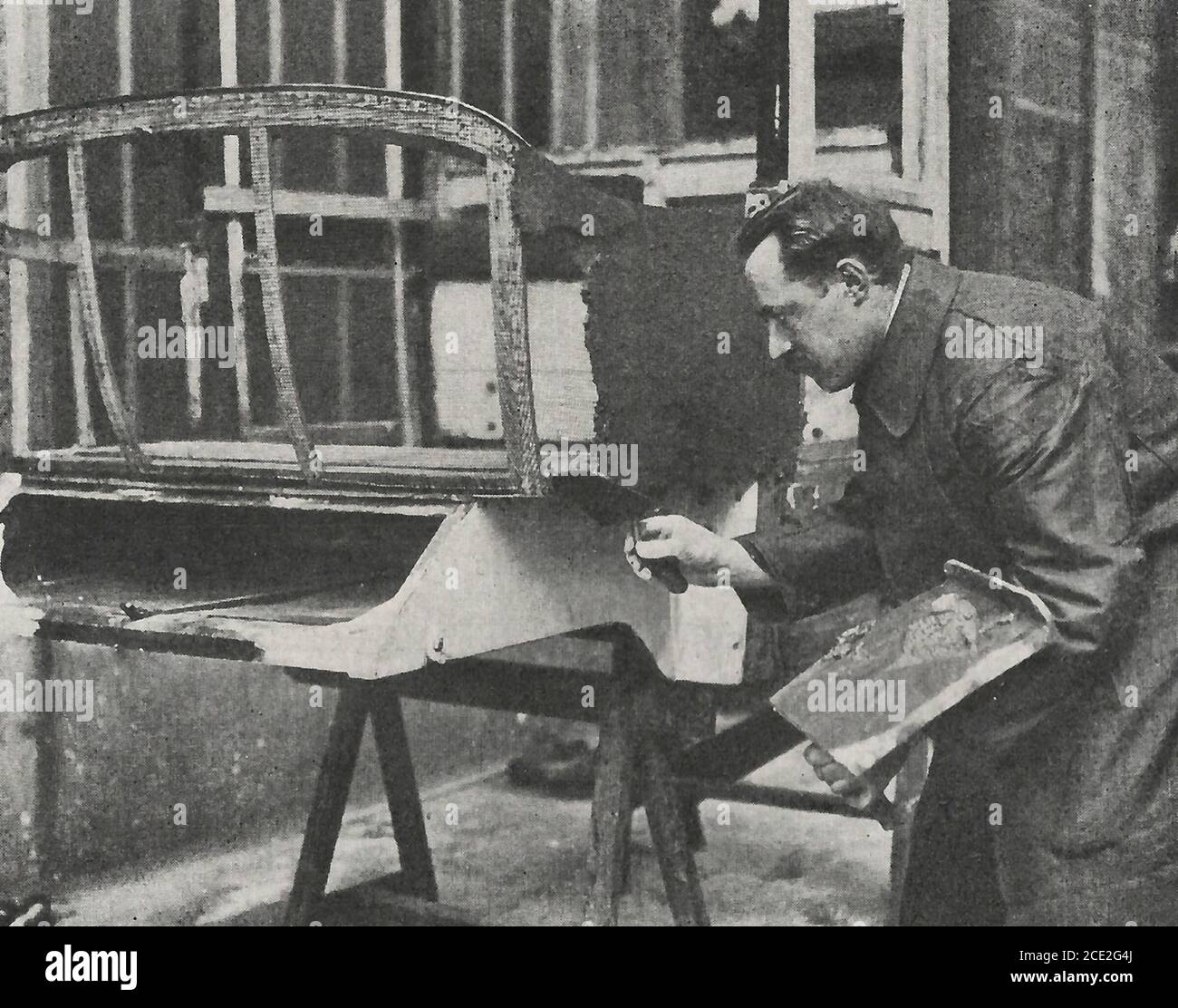Il modellatore che applica l'intonaco alla rete metallica - fabbricazione di un'automobile, circa 1914 Foto Stock