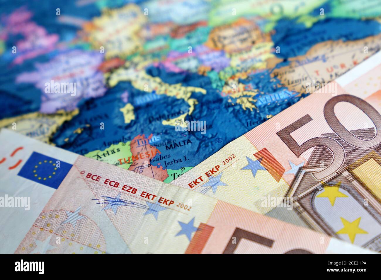 Banconote in euro sulla mappa dell'Europa. Concetto per l'economia europea, i paesi dell'eurozona Foto Stock