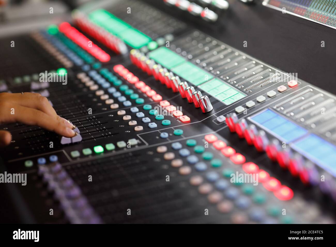 Console di mixaggio audio digitale con fader a portata di mano. Messa a fuoco selettiva. Foto Stock
