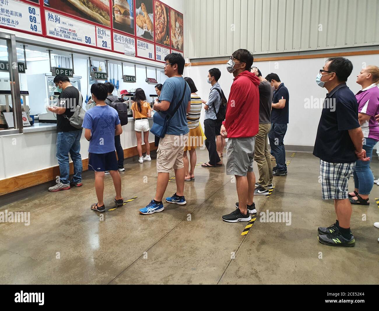 Hsinchu / Taiwan - 28 agosto 2020: I clienti asiatici in coda mantenendo una distanza sociale sicura al ristorante del supermercato Costco Foto Stock