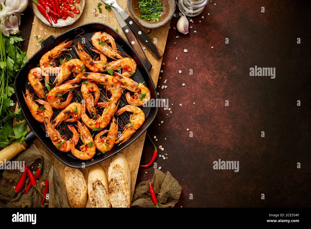 Gustosi gamberi arrosto con spezie in padella con ingredienti su fondo arrugginito Foto Stock
