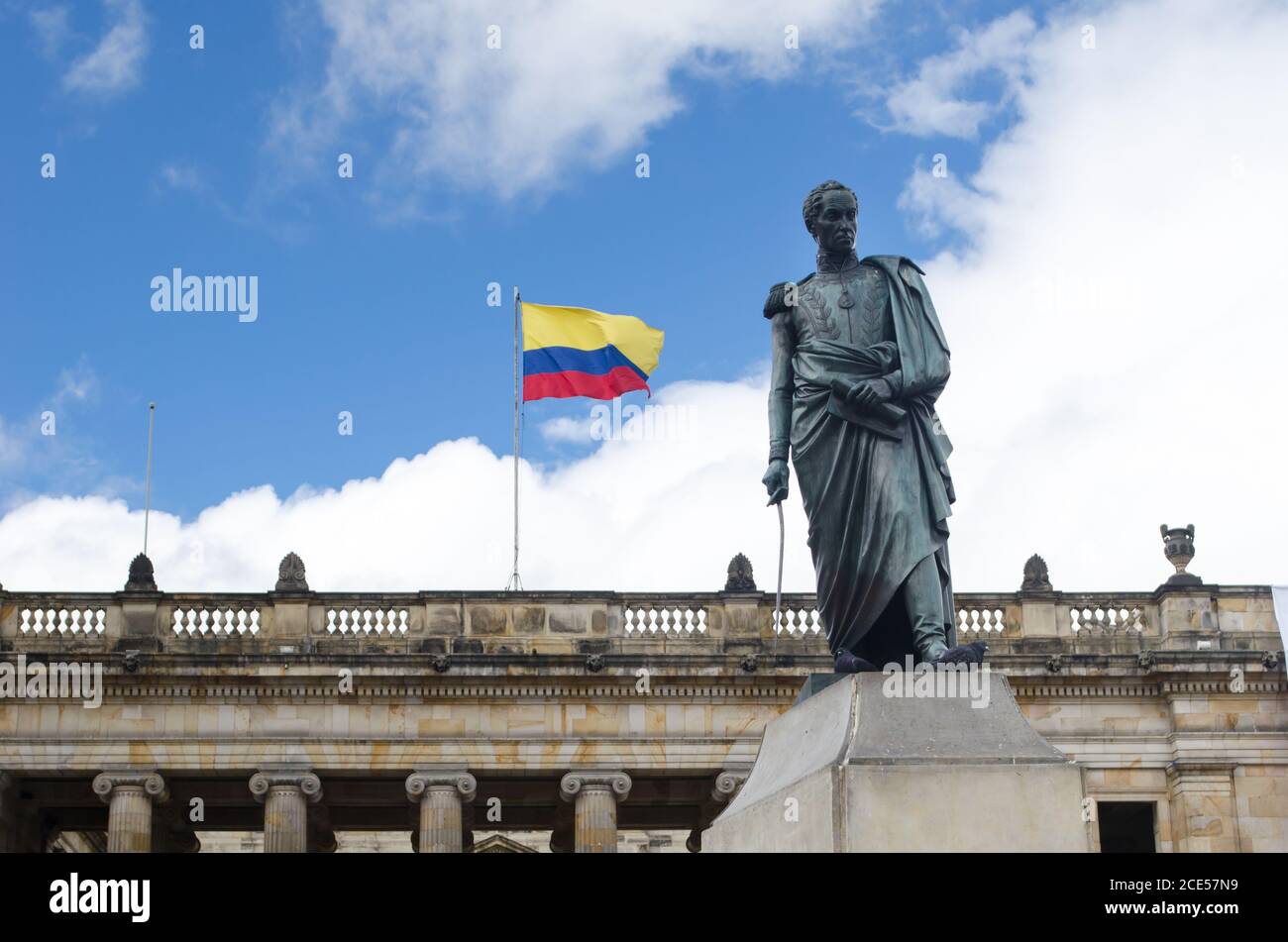 Facciata del Capitolio Nacional in piazza Bolivar a Bogotà. Sono inoltre visibili la bandiera colombiana e la statua di Bolivar Foto Stock
