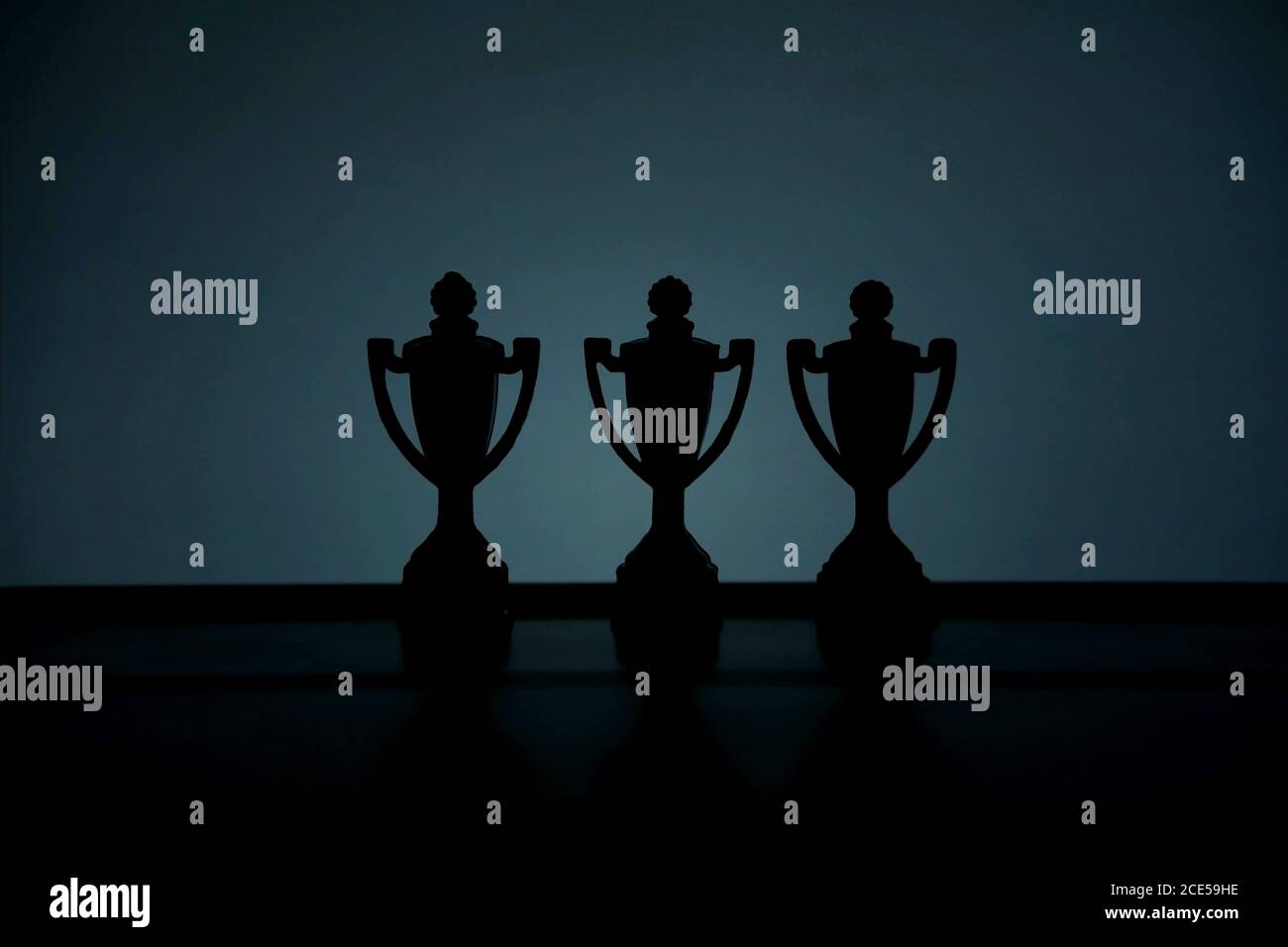 Foto concettuale della strategia aziendale – Silhouette dello stand trofeo al centro del tavolo da ufficio Foto Stock