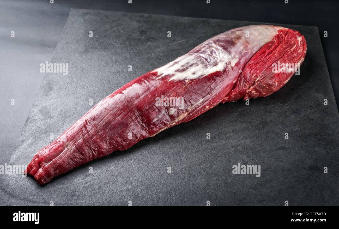 Bistecca di filetto di manzo stagionato, naturale come primo piano su nero sfondo con spazio di copia Foto Stock
