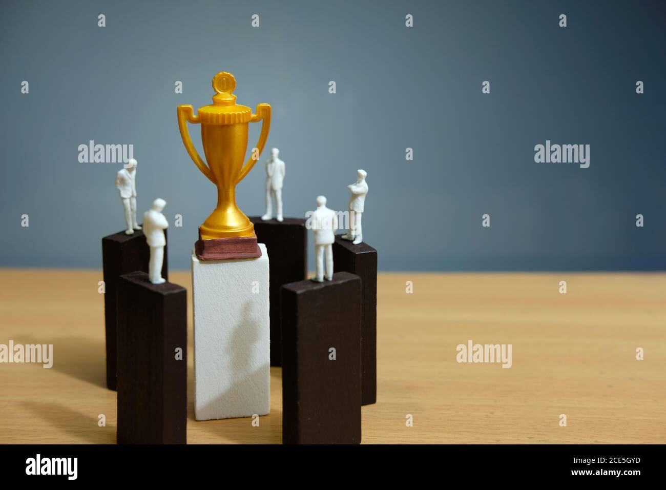 Foto concettuale aziendale – miniatura di gruppo di uomini d'affari hanno un discussione di gruppo sopra blocco di puzzle di legno per raggiungere trofeo d'oro Foto Stock