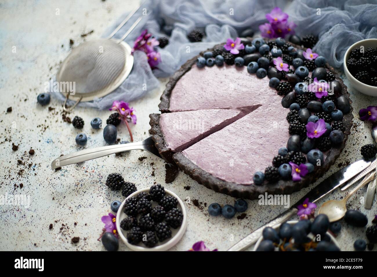 Pezzo fatto in casa di mirtillo, mora e torta d'uva tagliata da una torta servita a tavola. Foto Stock