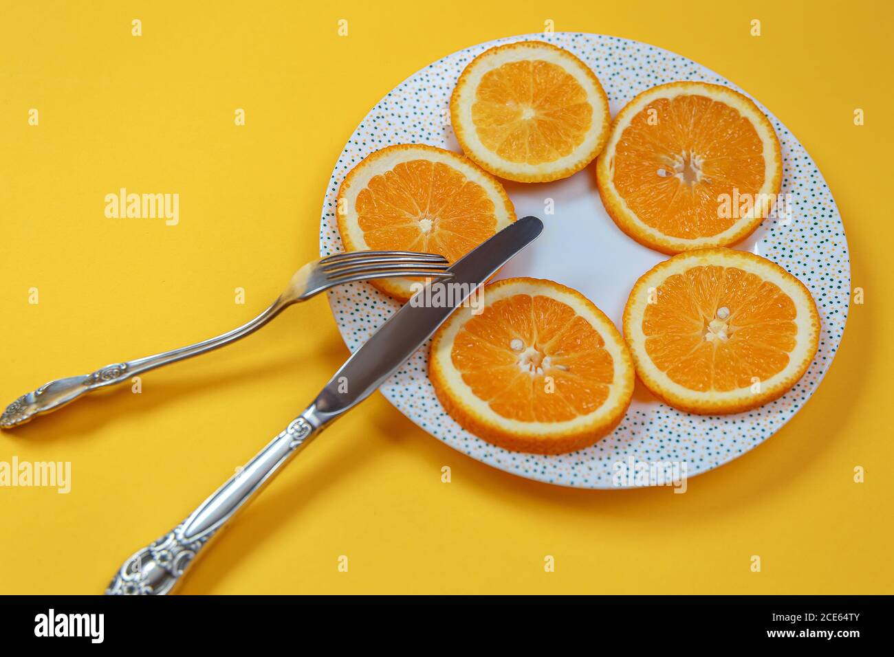 Fette arancioni su un piatto e un coltello con una forchetta. Concetto di dieta Foto Stock