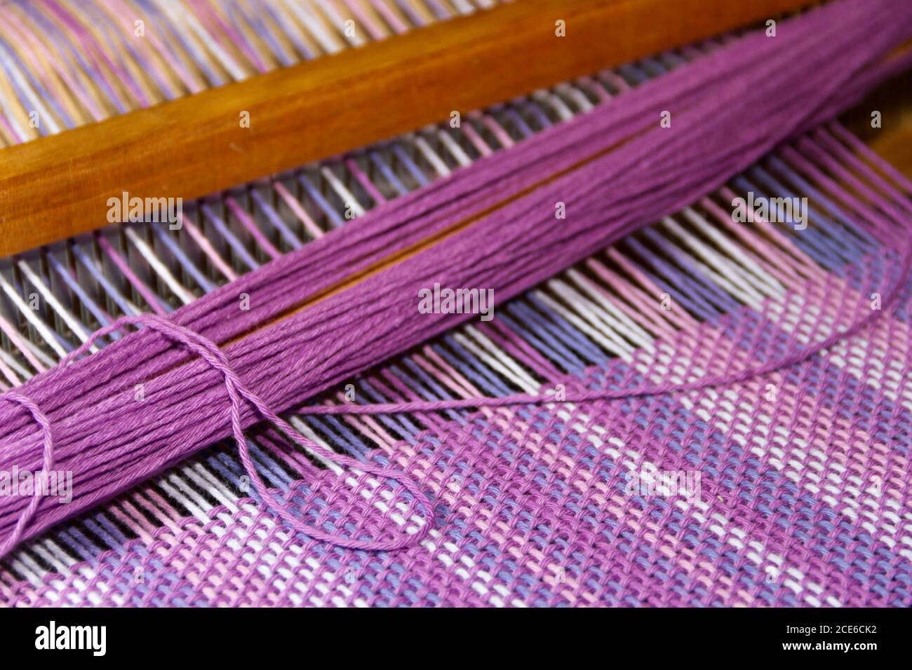 Dettaglio del tessuto a telaio a pettine con raggi ultravioletti e colori lilla Foto Stock