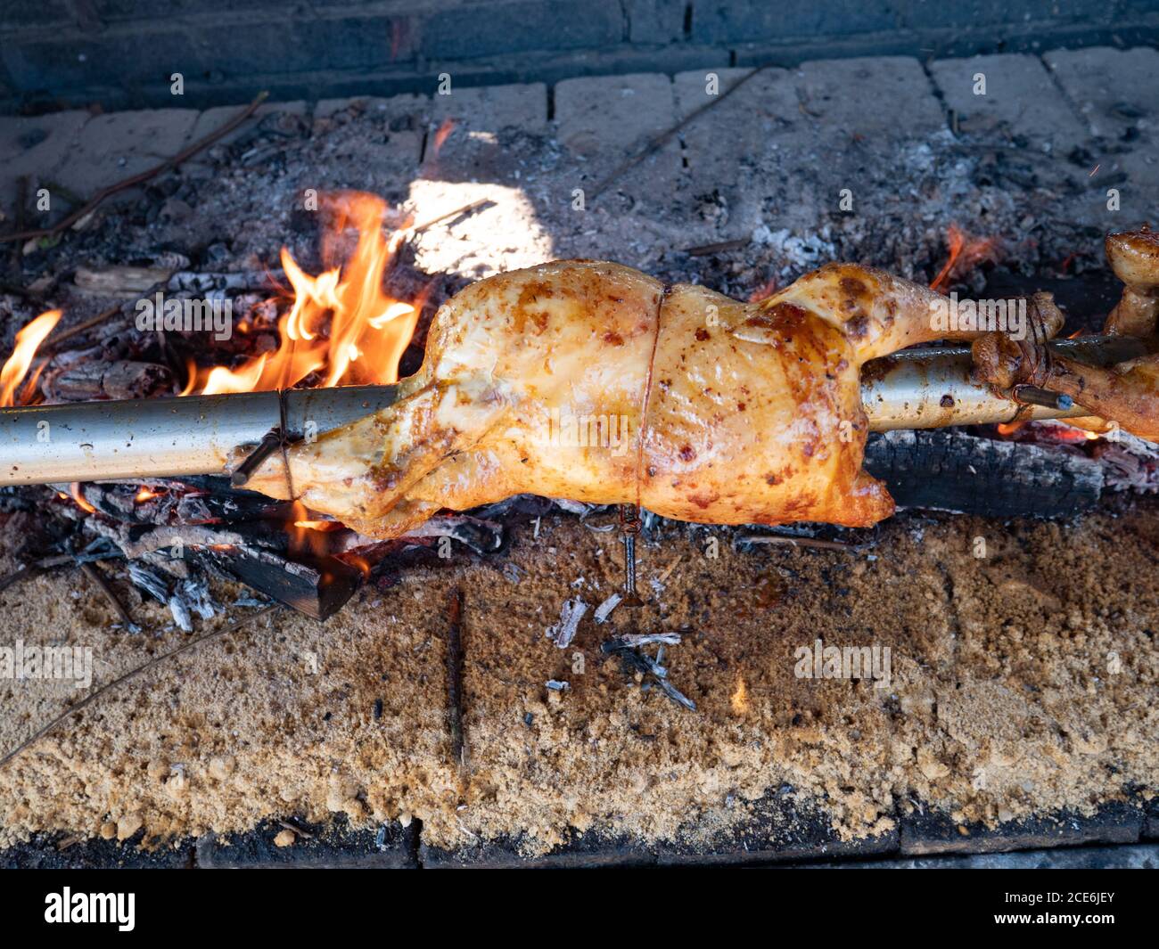 . Due polli su spit arrostire su saloni Foto Stock