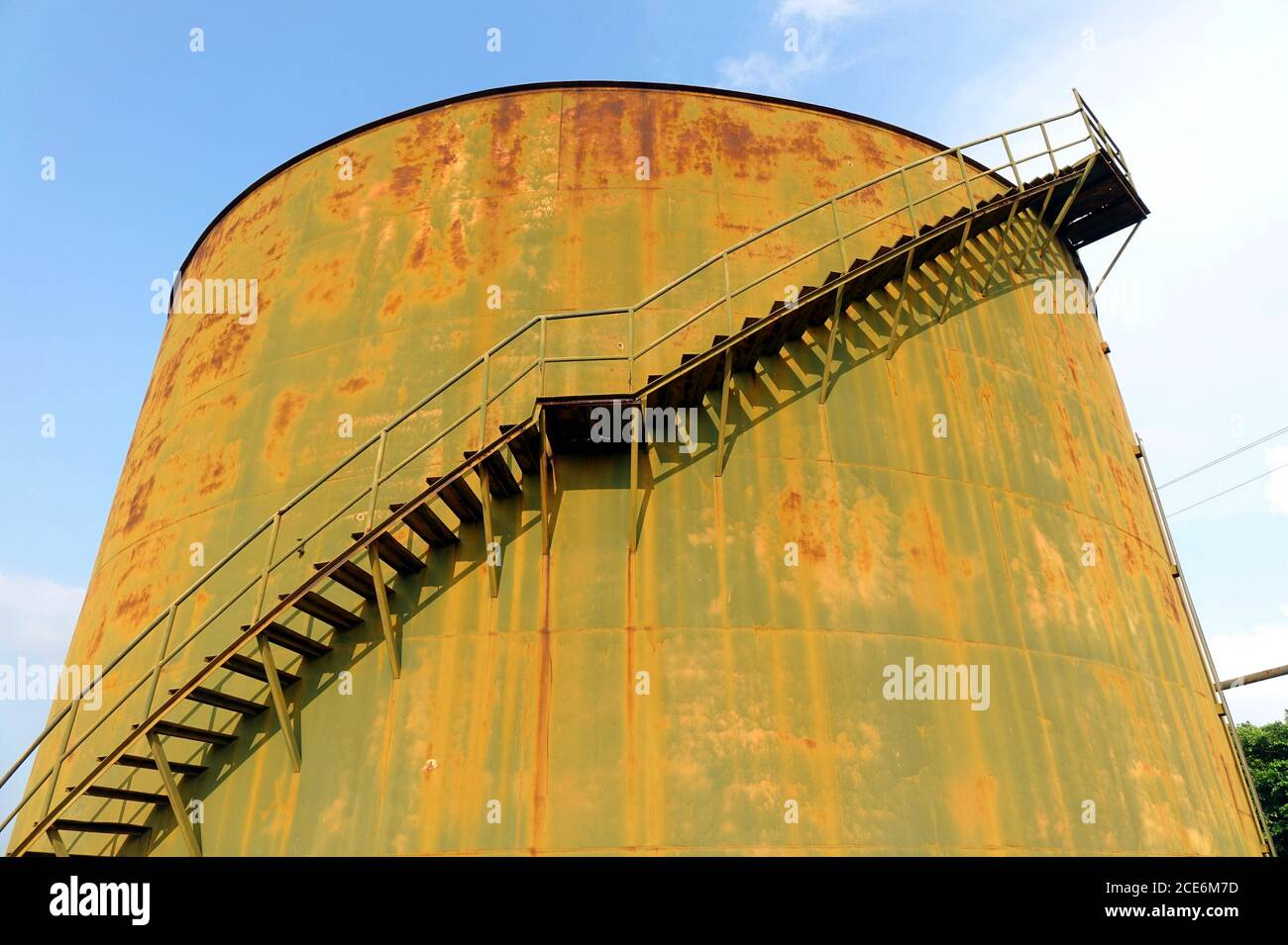 Una grande formazione di ruggine serbatoio di stoccaggio ad un vintage impianto industriale Foto Stock