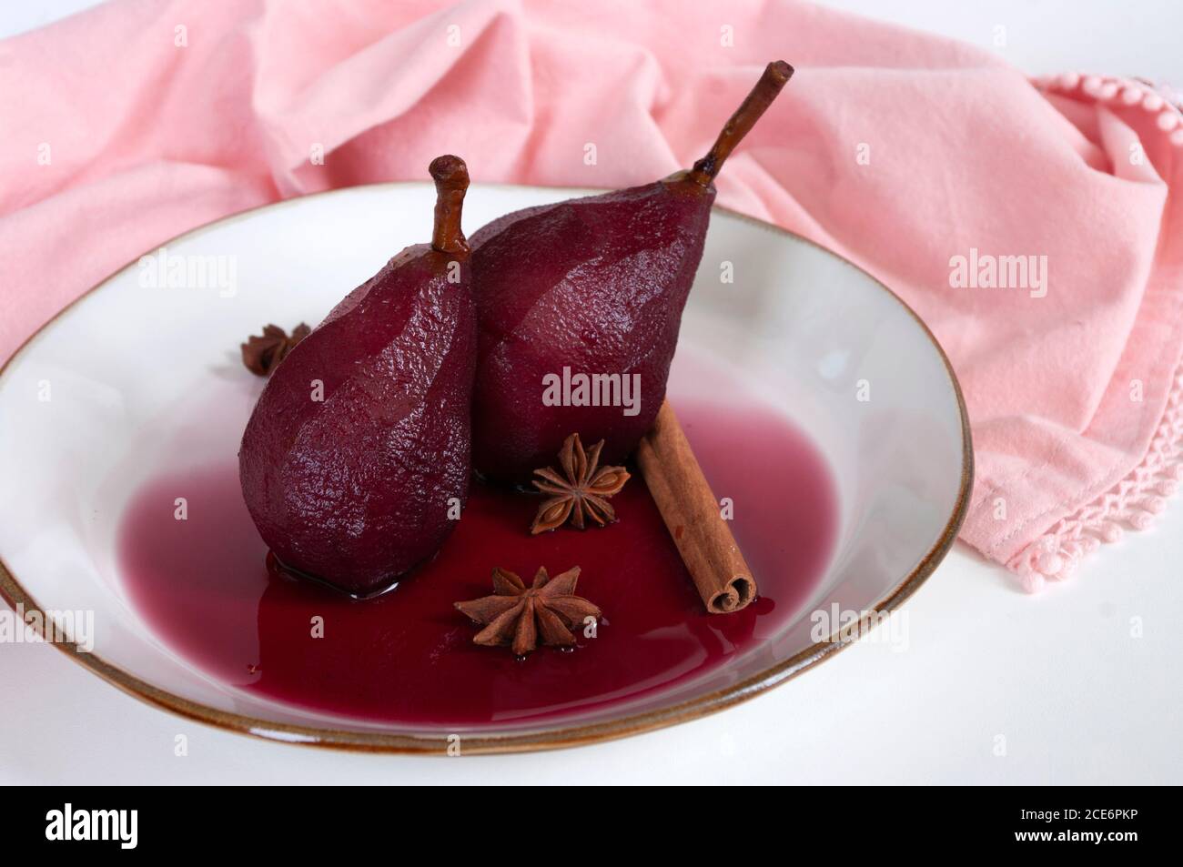 Dessert di frutta, pera in camicia al vino rosso con cannella, cucina italiana, delizioso. Foto Stock