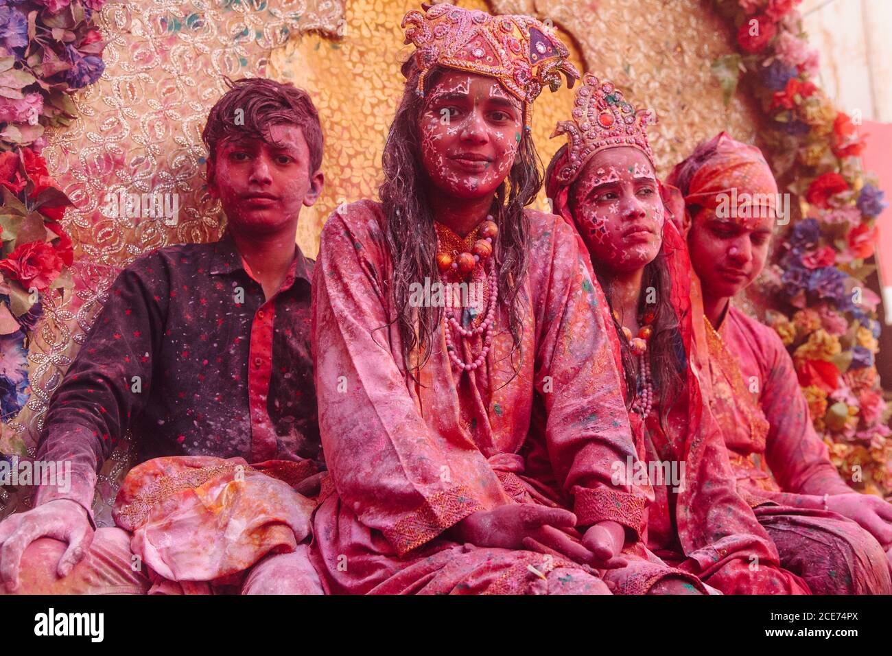 India - 9 marzo 2020: Compagnia di giovani indiani in abiti fantasia e con volti dipinti che si rilassano in città durante il festival Holi Foto Stock
