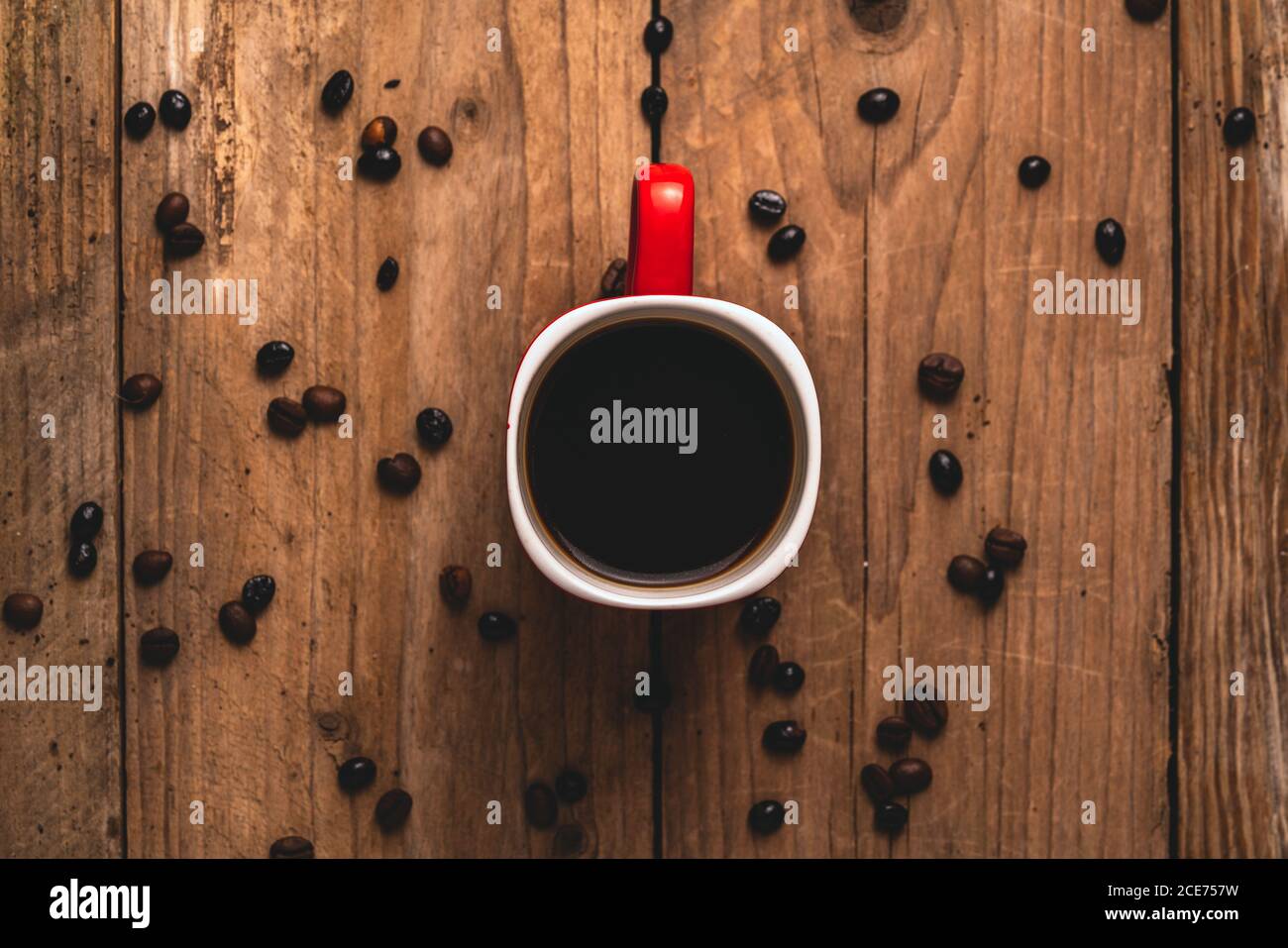 Vista dall'alto della deliziosa bevanda in tazza collocata sul tavolo con chicchi di caffè Foto Stock