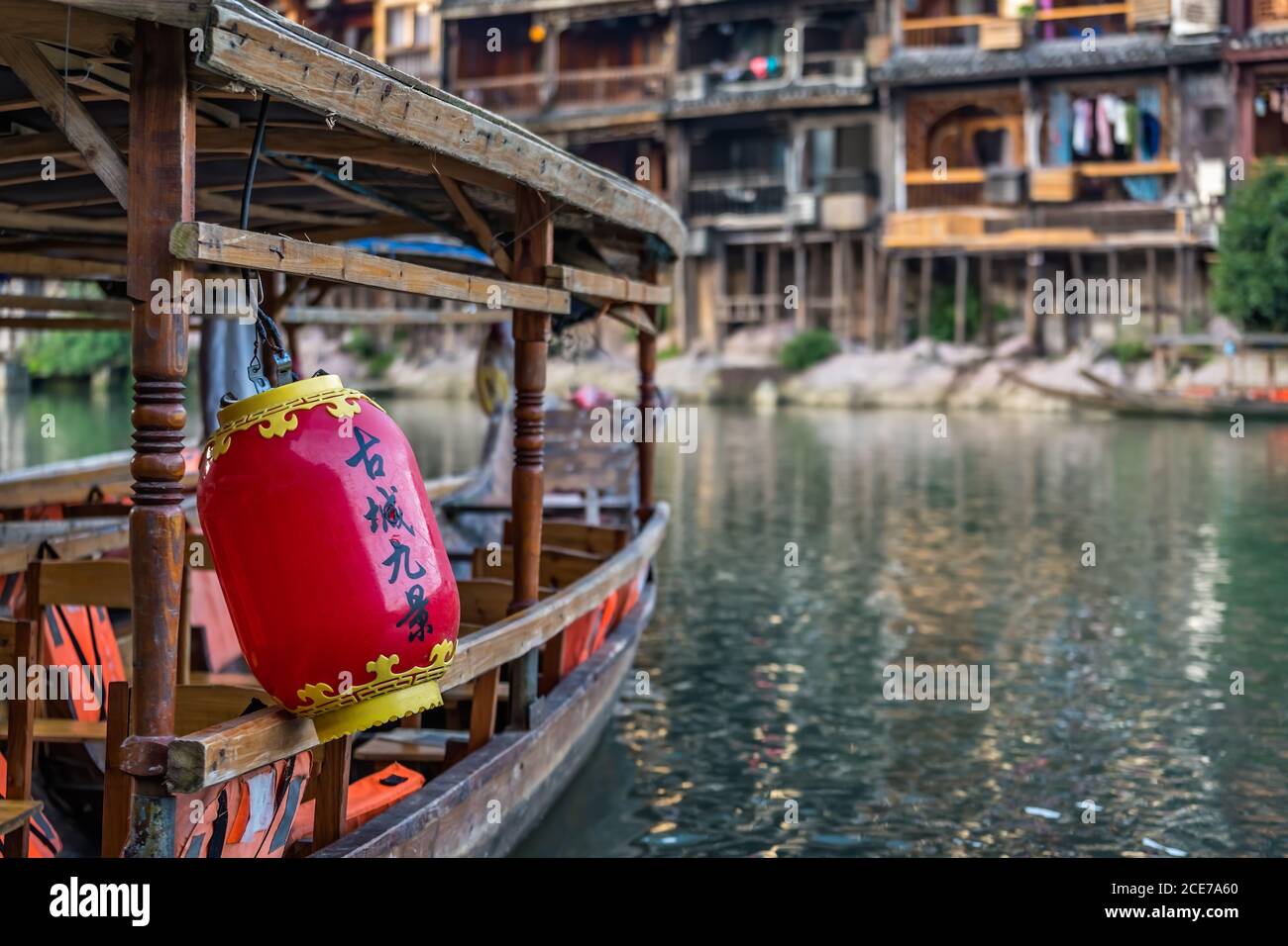 Lanterna rossa sulla vecchia barca di legno ormeggiata su Tuo Riva del fiume a Fenghuang Foto Stock