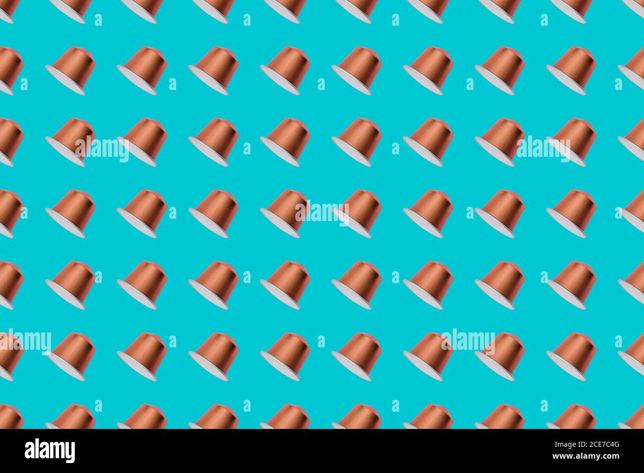 Vista dall'alto delle cialde di caffè dorate disposte in file uniformi come motivo senza giunture su sfondo blu Foto Stock