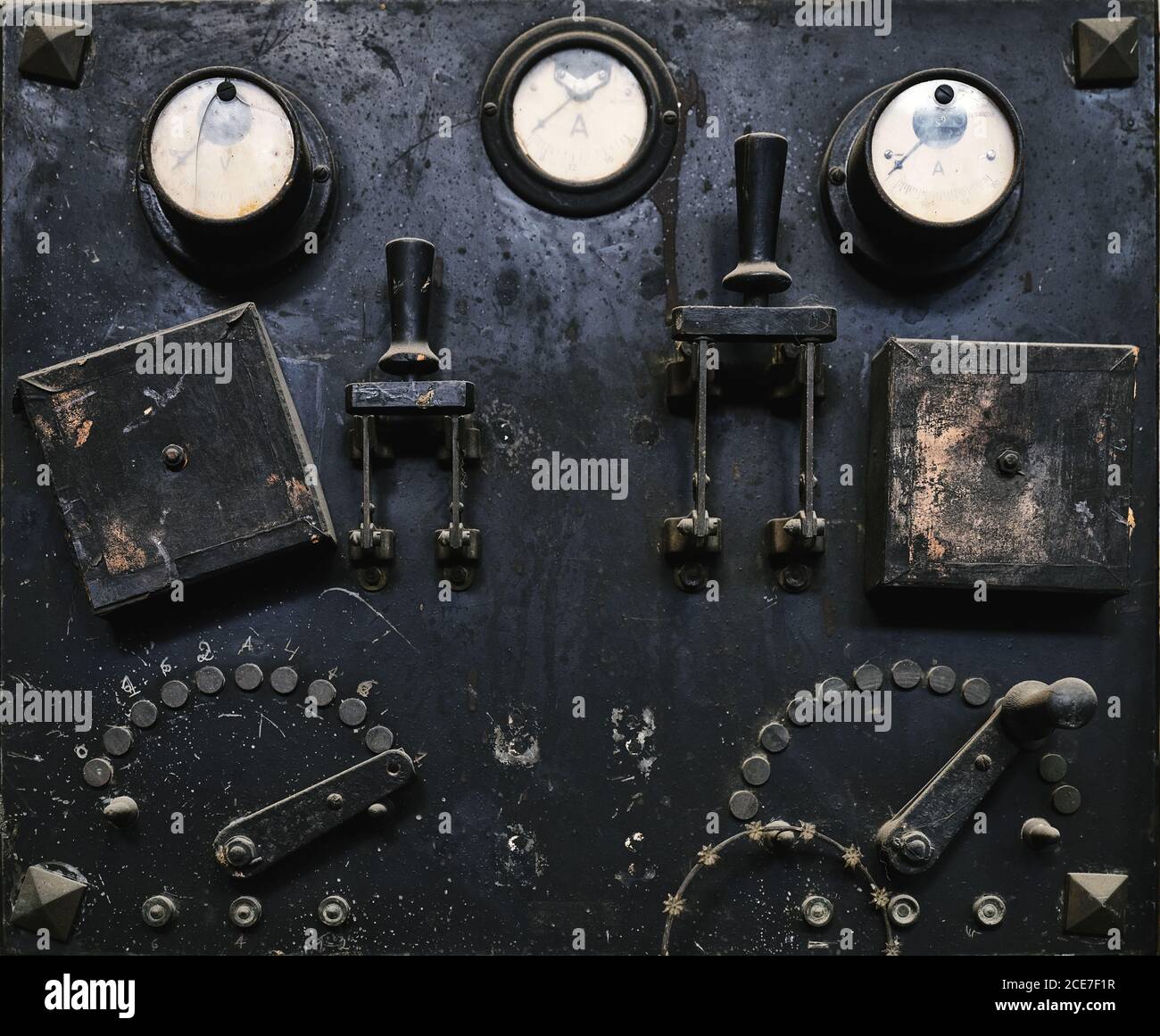 Pannello di controllo in metallo invecchiato con interruttori e indicatori analogici in officina artigianale Foto Stock