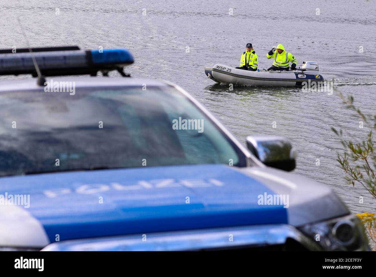 Dresda, Germania. 28 Agosto 2020. Poliziotti della polizia dell'acqua con motoscafo su un lago. In primo piano ha lasciato una macchina di polizia. Credit: Tino Plunert/dpa-Zentralbild/ZB/dpa/Alamy Live News Foto Stock