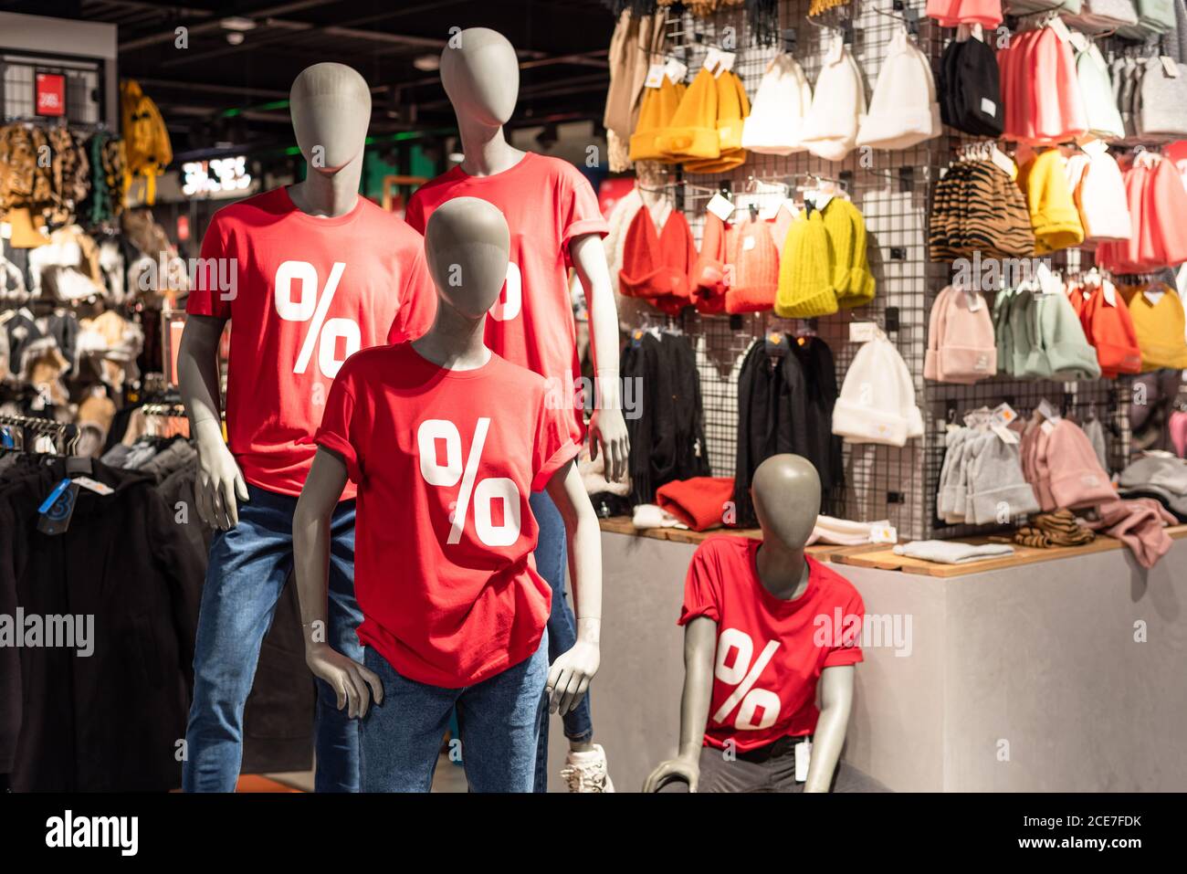 Manichini vestiti in t-shirt rossa con segno percentuale e jeans blu nel centro commerciale. Stagione di sconti e vendite. Black Friday Foto Stock