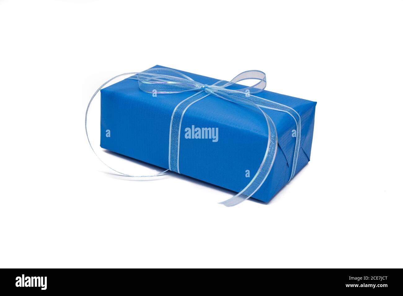 Confezione regalo confezionata in carta blu di tendenza su sfondo bianco. Colore blu classico. Composizione festiva in stile minimal. Concetto di vacanza. Derisione Foto Stock